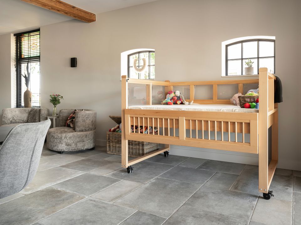 Moderne woonkamer met een speciaal bed voor een kind dat zorg nodig heeft, wat de focus van Gelderse Bouwmeesters op het creëren van comfortabele en functionele ruimtes voor kinderen met bijzondere behoeften benadrukt.